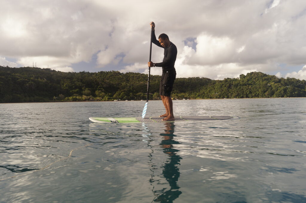 Man stand up paddling in front of the resort
