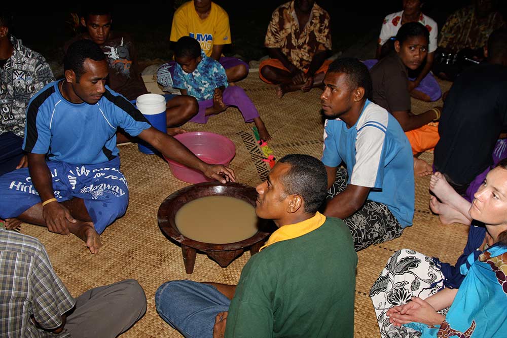 Fijian men and resort guests having a kava ceremony