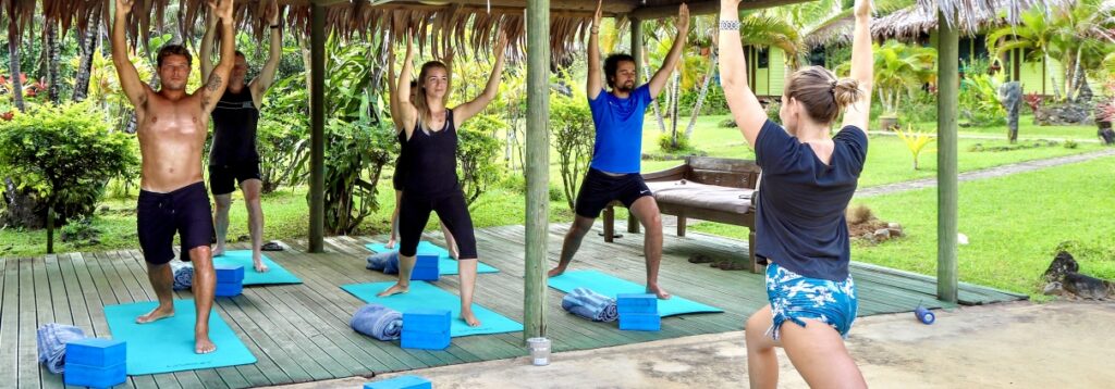 Guests practicing yoga on the outdoor deck at Waidroka Bay Resort