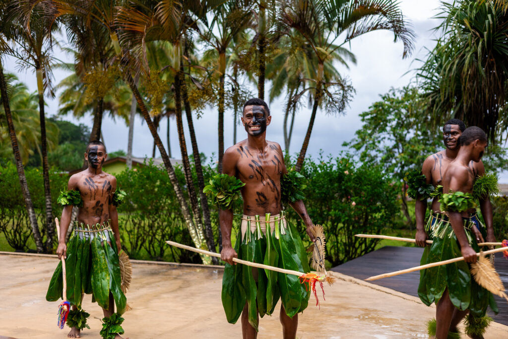 Three Fijian men dressed as warriors