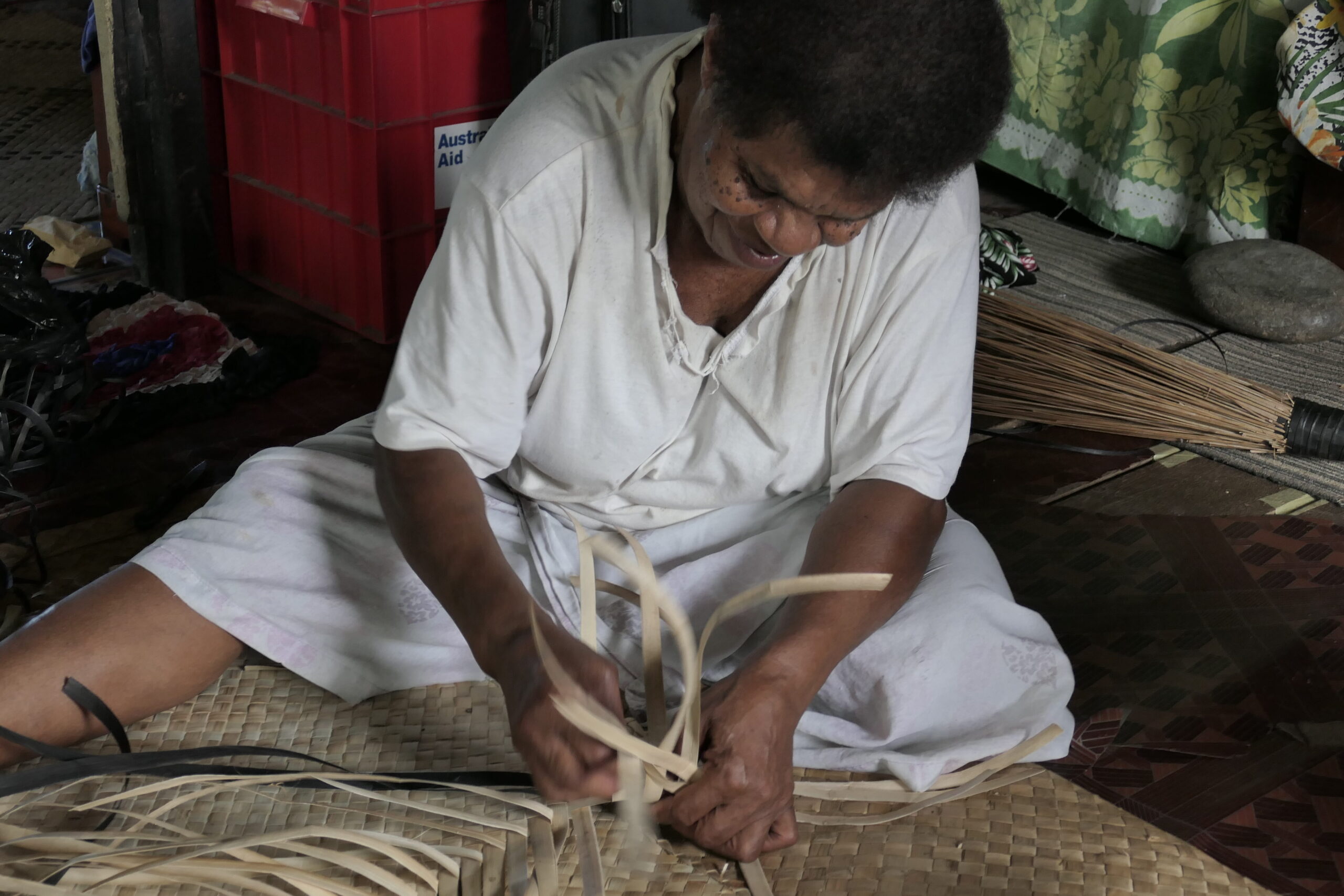 Lady in the village weaving a mat