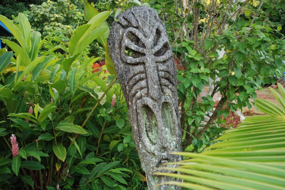 Tiki carving in the garden made from palm tree